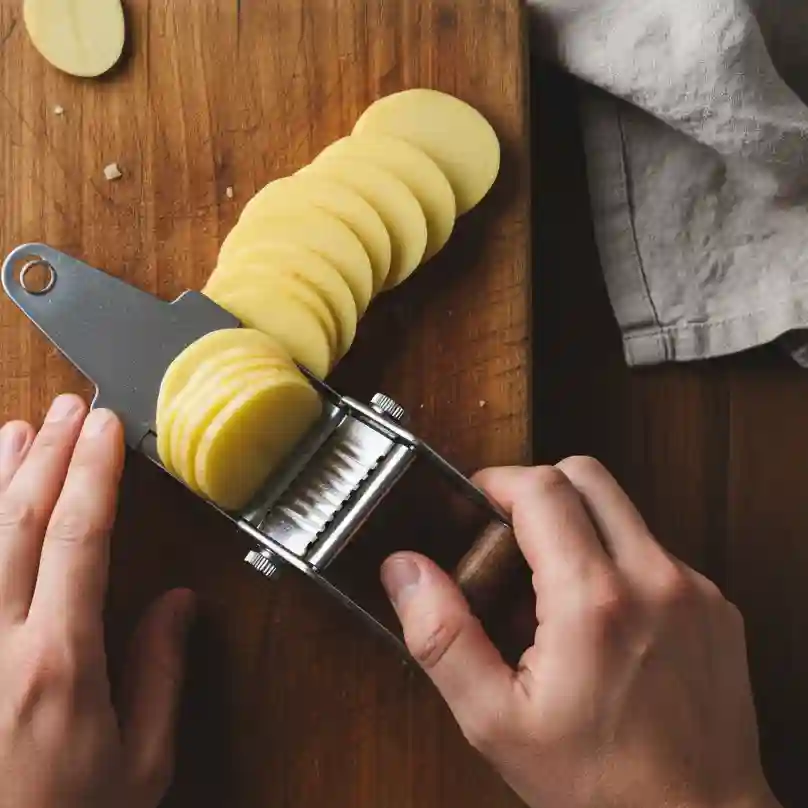 Gratin dauphinois traditionnel : la recette authentique, astuces et variantes 5 Découpe de pommes de terre en tranches fines et régulières de 3-4mm avec une mandoline pour gratin dauphinois